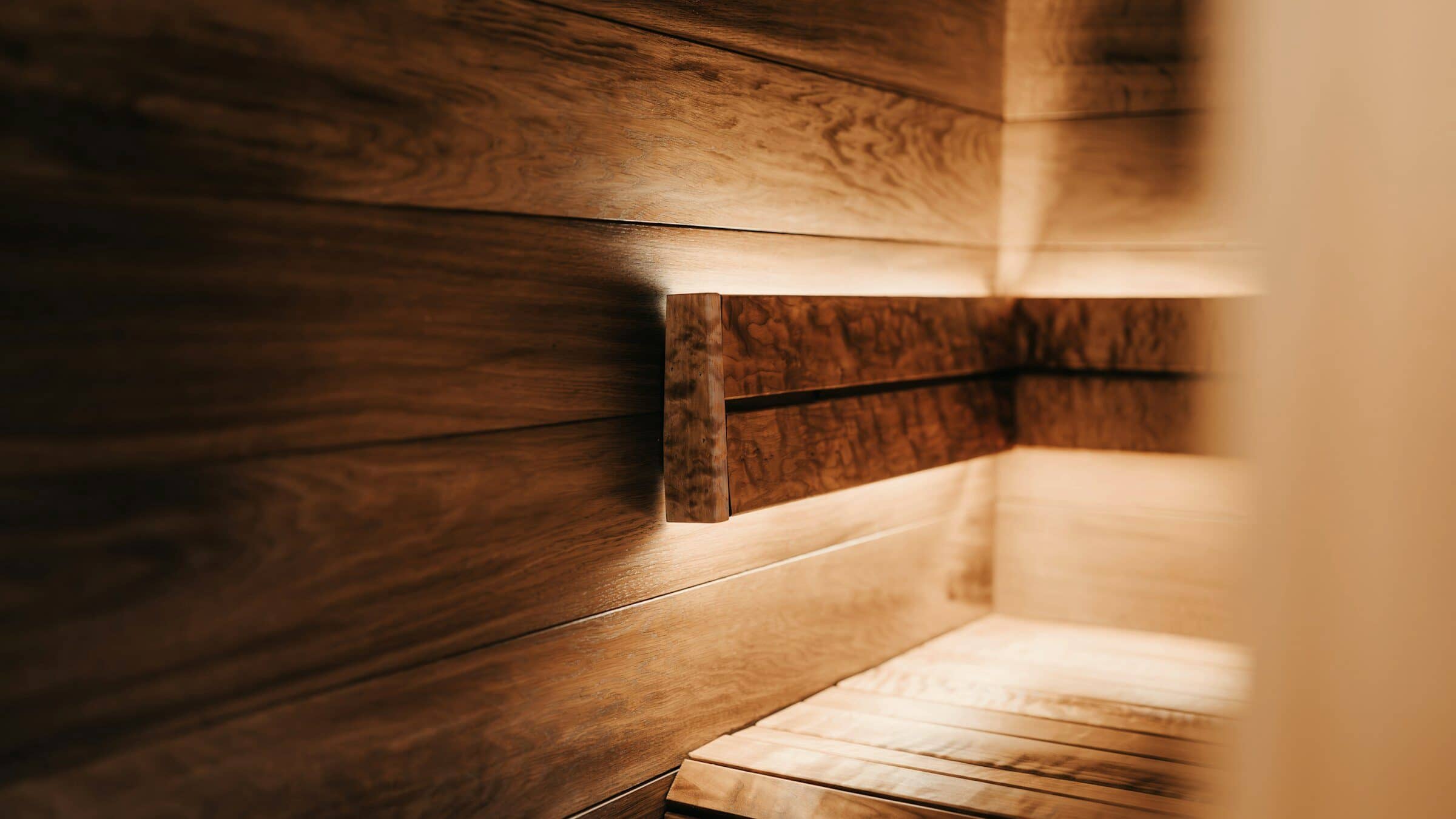 Interior de residencia con luz natural y materiales cálidos, ventanal abierto hacia un jardín