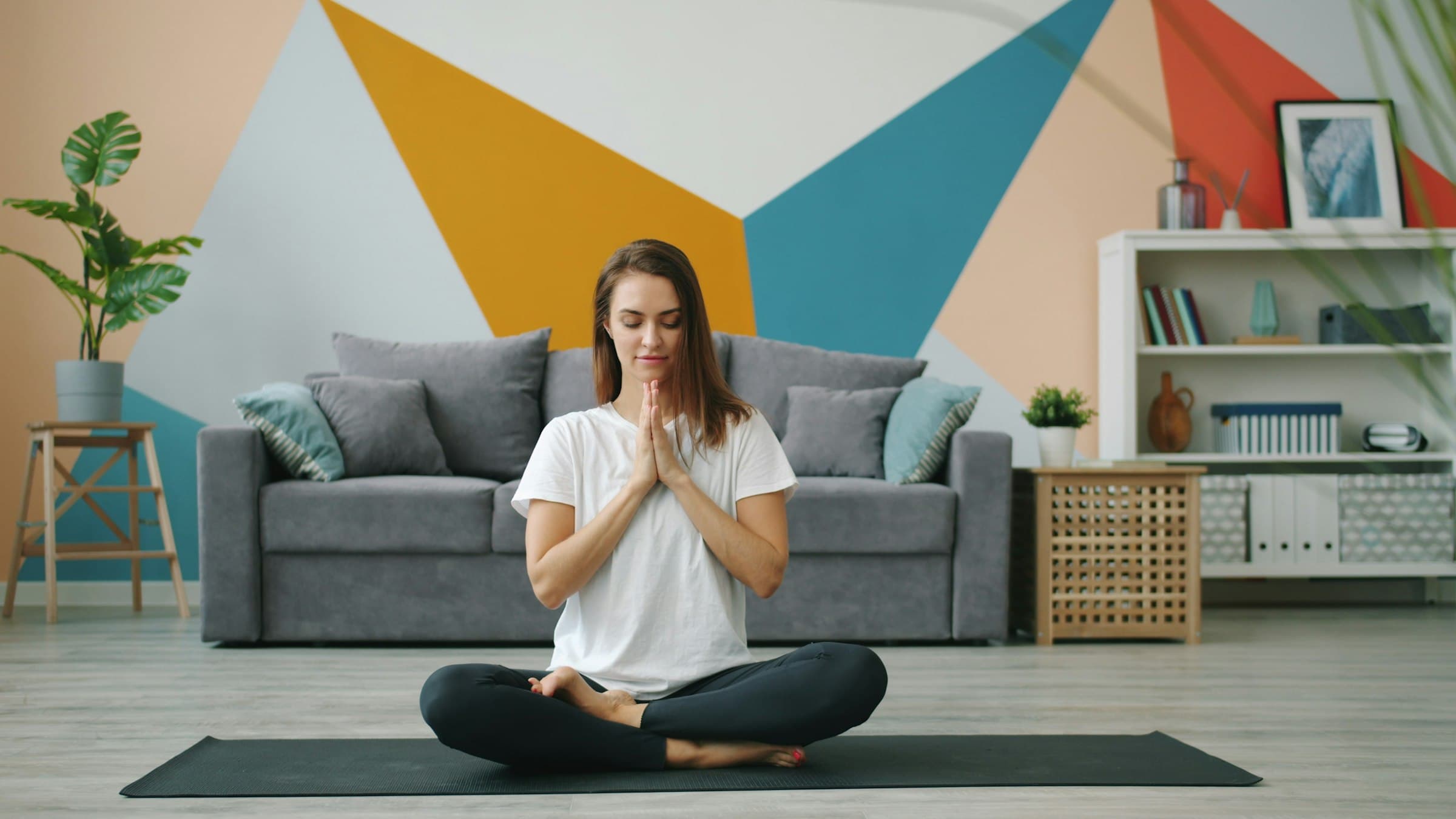 Una mujer serena meditando al amanecer en un espacio tranquilo, simbolizando un comienzo de día pacífico.