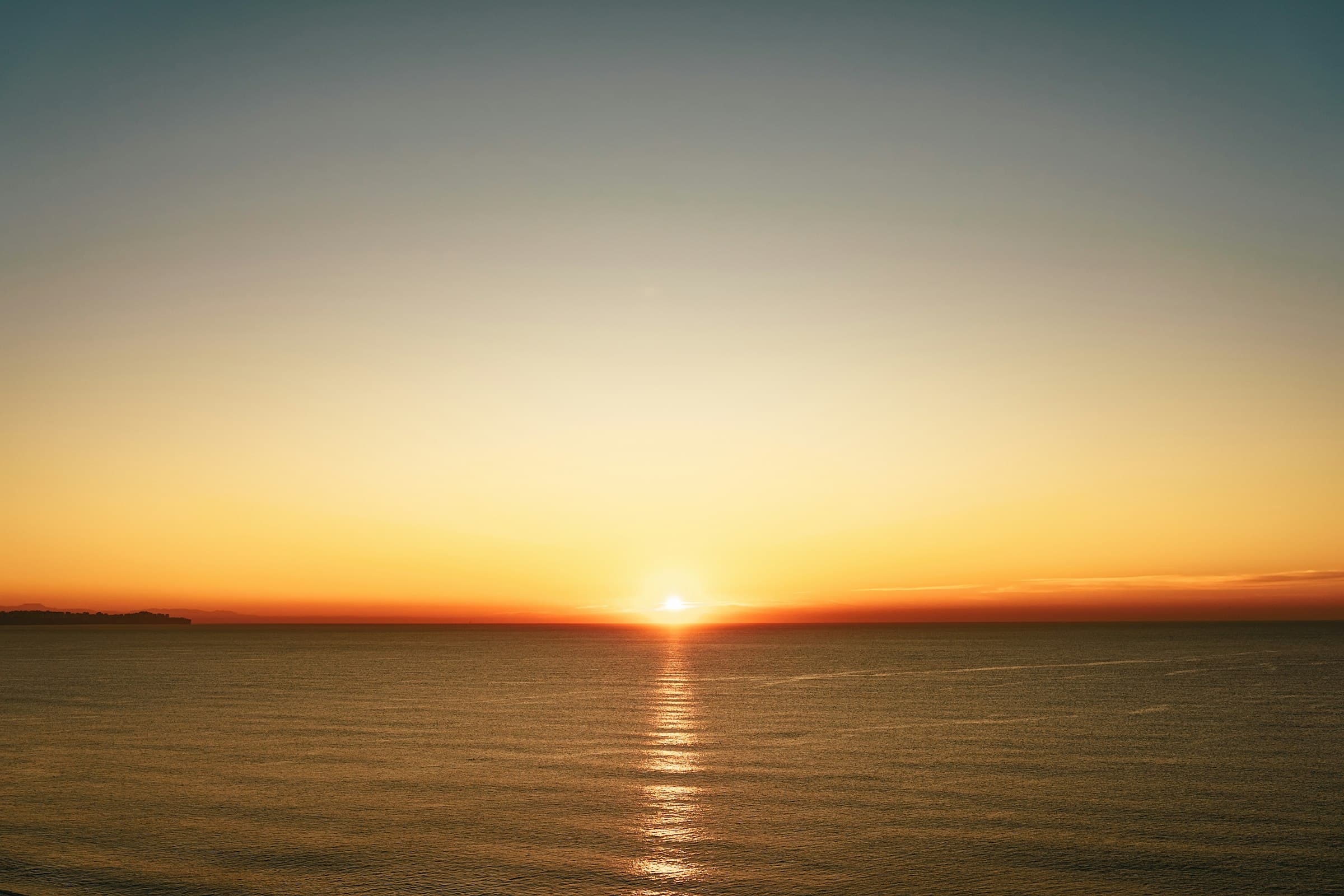 Una persona meditando tranquilamente al amanecer, con una luz suave y cálida iluminando el espacio