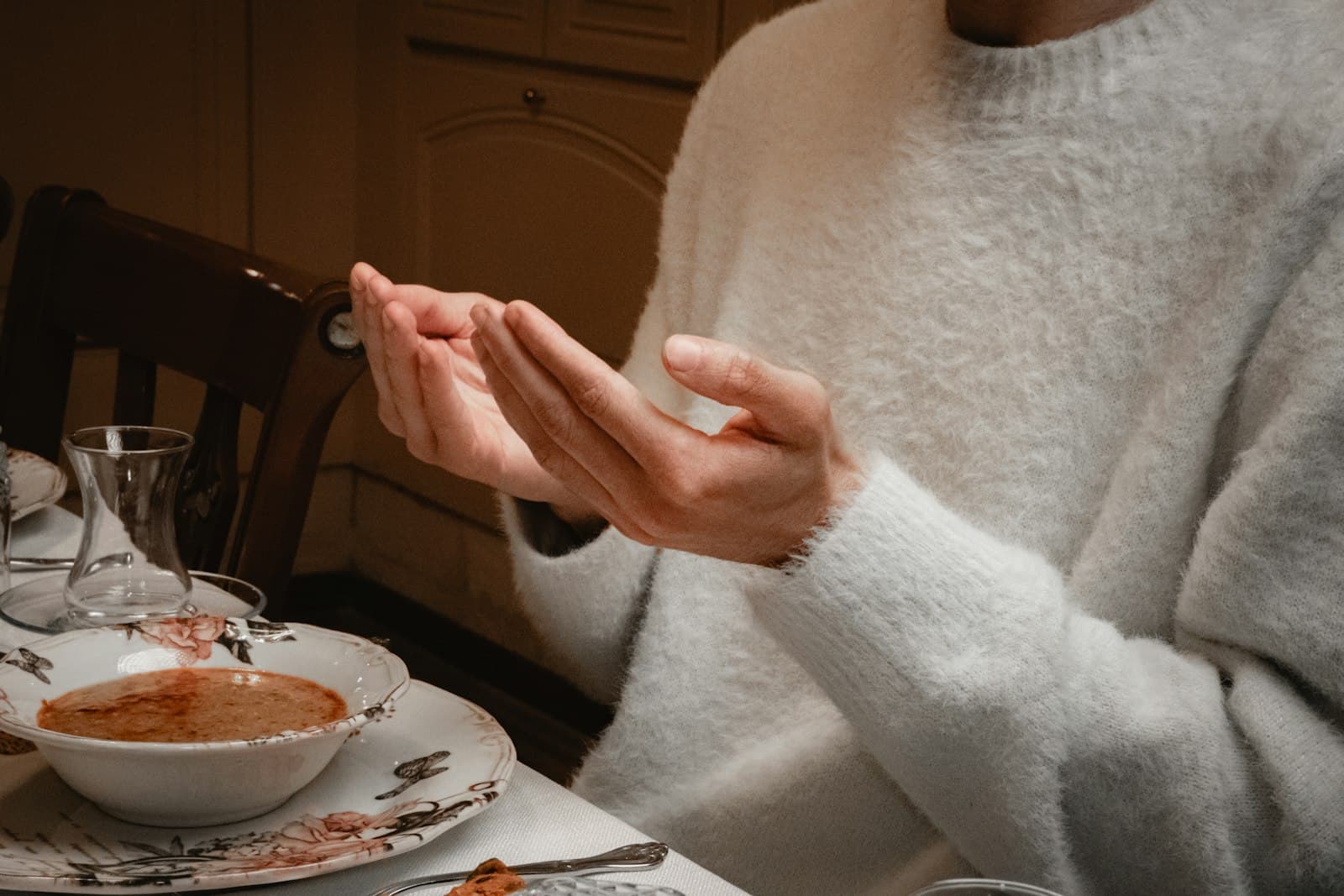 Manos sosteniendo una taza de té caliente en un ambiente acogedor, promoviendo la relajación.