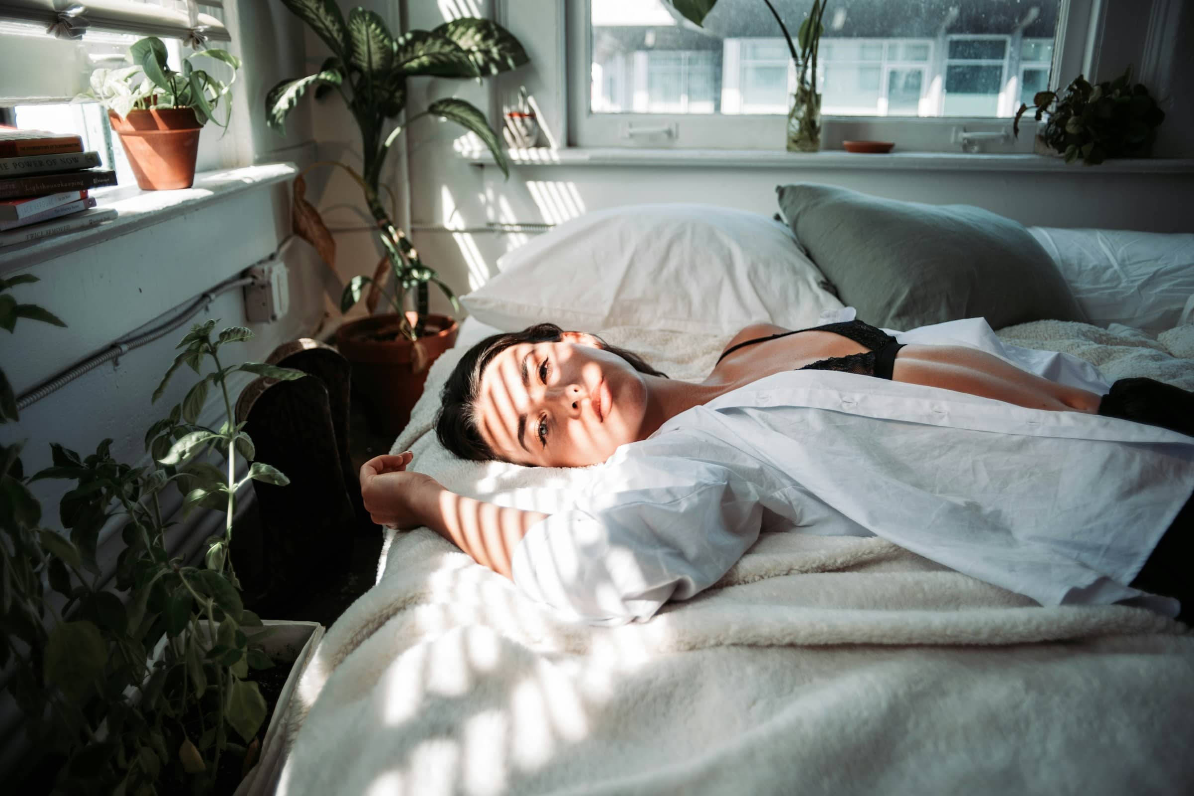 Una persona durmiendo plácidamente en una cama con luz natural, simbolizando el descanso profundo.