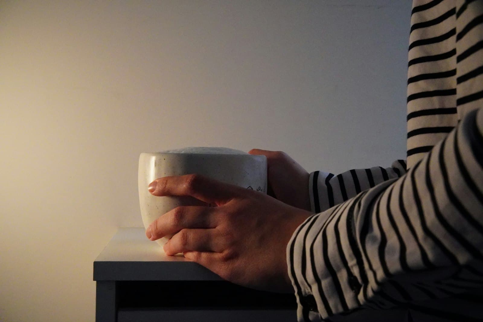 Manos sosteniendo una taza caliente en un momento de atención plena matutina.